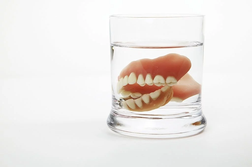 Dentures Dipped In A Glass Of Water